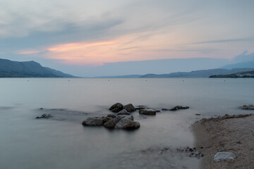 Stones near sea coast in long exposure during sunset, seaside landscape
