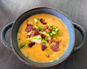 Loaded Potato Cheese Soup garnished with onions, chives, bacon, sour cream and cheese.