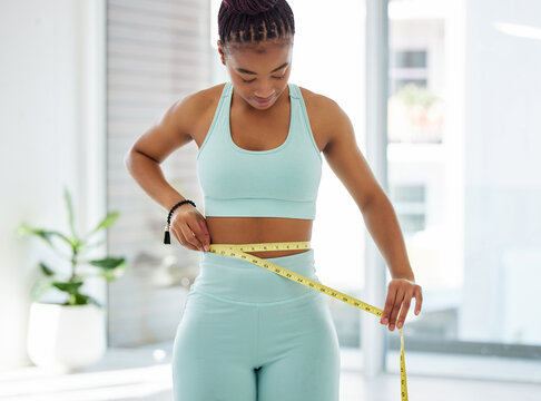 Fitness, health and black woman with tape measure in home for weight loss, track progress and exercise goals. Waist, wellness and person with measurement for diet, training and workout results