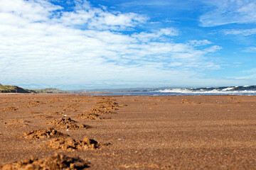 Obraz premium Picture of a deserted beach with dunes and footprints in Scotland during the day