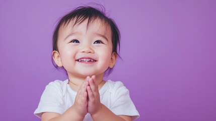 A baby girl in a white shirt is smiling.