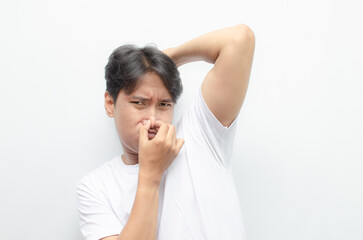 young asian man in white tshirt feeling embarrased because of his body odor. man smelling bad odor...