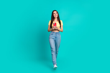 Full body portrait of pretty young woman walk look empty space wear top isolated on turquoise color background