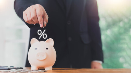Concepts of saving money and financial planning. Man hand holding piggy bank on wood table, income,...