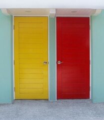 Yellow and red room door mounted on green wall.