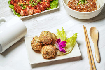 Homemade dace fish balls with pork chop, minced pork rice served in dish isolated on marble background side view of taiwan food
