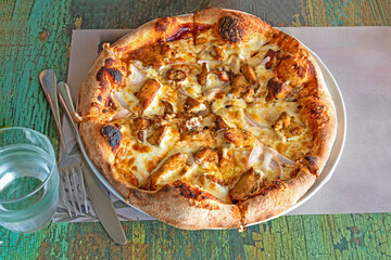 Baked pizza on a plate outside in restaurant