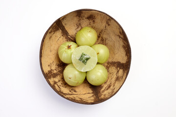 Amloki Indian gooseberry herbal medicinal healthy fruit on white background in coconut shell bowl
