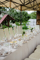 A summer tent with tables, food  and chairs on the wedding day