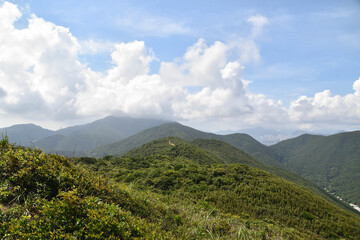 The Dragon's Back hiknig trail in Hong Kong with verdant green mountains.