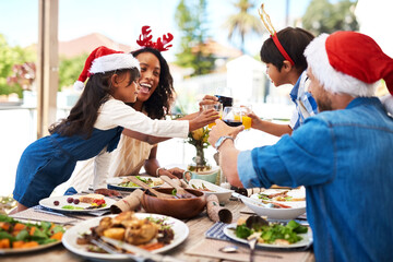 Parents, kids and toast with food on Christmas at table on patio for lunch and celebration at home. People, family and happy for festive season or holiday for gathering, support and love with smile