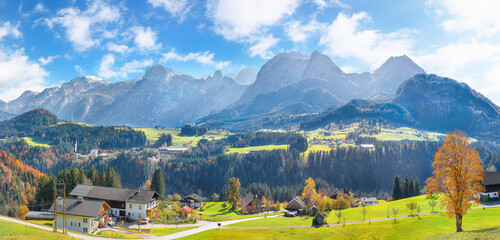 Breathtaking view of  Alpine green fields and traditional wooden houses near Abtenau village at...