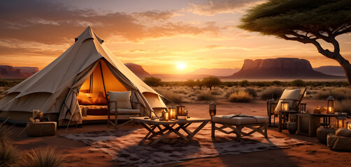 A stunning desert sunset accents a safari tent with safari furniture, an appealing bed, and a separate lounge area