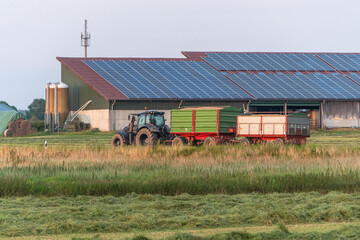 Ein Traktor mit Anhänger fährt die Straße entlang

