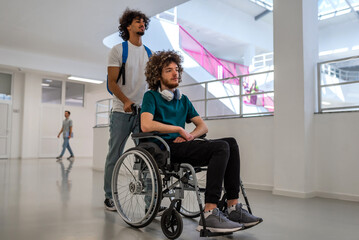 A group of happy diverse college students walking in the university hallway, a classmate pushing a...