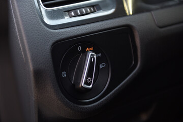 Dashboard light control dial in a modern vehicle cabin during nighttime