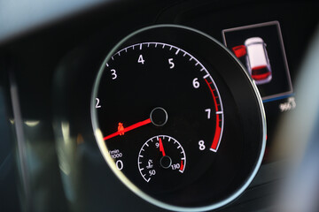 Car dashboard with speedometer and engine temperature gauge.