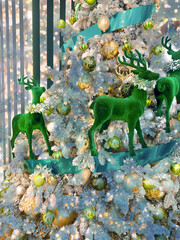 Card with reindeer decorating Christmas tree.