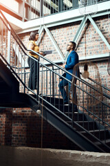 Naklejka premium Startup, steps or designers in discussion in office for creative project, teamwork or progress report. Organize, interior design and people with paperwork for brainstorming, planning ideas or update