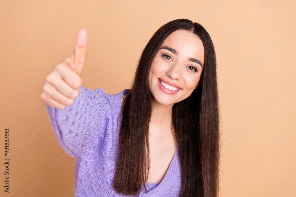 Wall mural Photo of pretty young woman show thumb up wear cardigan isolated on beige color background