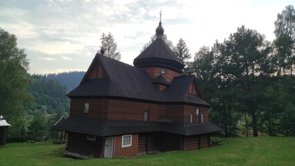old wooden church in the middle of a green field