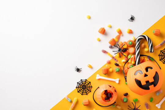 Creative Halloween arrangement with candy and festive decorations. Features a pumpkin bucket surrounded by sweets, spiders, and webs evoking a fun and spooky atmosphere