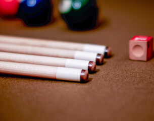 Pool cue sticks and billiard balls on felt with chalk 