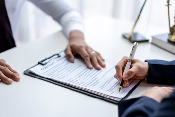 Two people are signing a contract