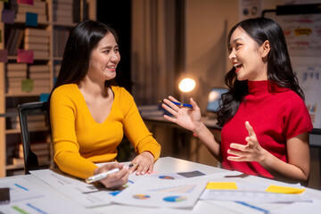 Two young businesswomen having a productive meeting discussing charts and documents