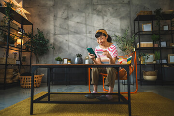 mature happy japanese woman buy online on cellphone with credit card