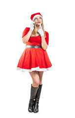 Young pensive Santa Claus woman talking on cell phone