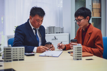 Real estate agent hands over keys to home to buyer after signing lease during home loan meeting. Property purchase agreement for new home ownership.