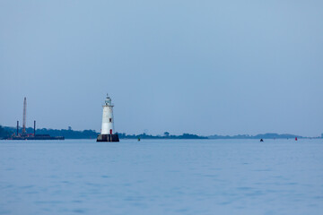 The Great Beds Lighthouse is seen across the Raritan Bay from South Amboy on a beautiful summer evening during golden hour
