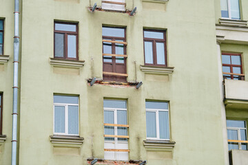 Building facade with dismantled balcony, structural repair, restoration and renovation historic building in progress. Structural repair and renew concrete reinforcement of balconies