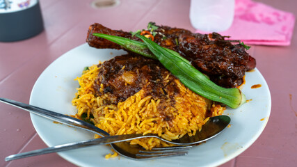 Indian dish Biryani chicken with basmati rice in metal brass old bowl, basmati rice with chicken, street food in Penang.