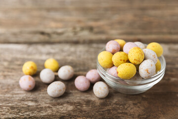 Easter chocolate egg on textured background. Easter celebration concept. Easter chocolate rabbit. Chocolate sweet eggs. Candies on textured wooden table. Space for text.Copy space. Gift. Banner.