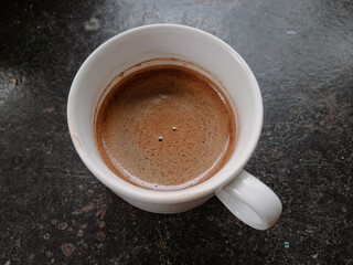 A white coffee cup with espresso on the table
