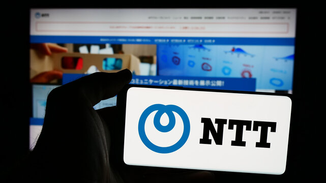 Stuttgart, Germany - 08-18-2024: Person holding smartphone with logo of company Nippon Telegraph and Telephone Corporation (NTT) in front of website. Focus on phone display.
