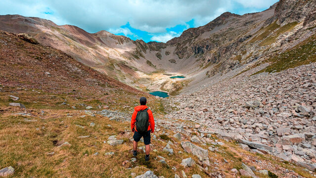 A mountaineer enjoys a day of exploration in the valleys of Pico Eriste, surrounded by the impressive peaks of the Eristes, the ibones of Bag&uuml;e&ntilde;ola and abundant vegetation, in Huesca.