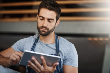 Cafe, worker and man with internet on tablet for online order, processing or digital service. Small business, waiter and reading with tech at coffee shop for web sale, communication or restaurant app