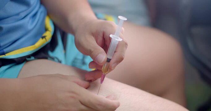Insert the syringe into the leg and pull the syringe stem to check for blood before injecting.Syringe with liquid being drawn into syringe.Testosterone.