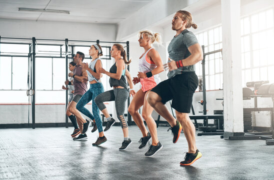 Sports, people and group of athletes in gym for health, wellness and body workout. Team, warm up and personal trainer challenge with active routine for cardio exercise at class in fitness center