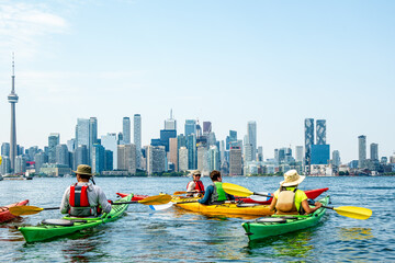 healthy active urban lifestyle: sea kayakers on toronto's inner harbour with the city skyline in...