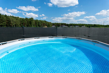 Large expansion pool with a diameter of 3.96 m, located in the yard on the grass.Large expansion pool with a diameter of 3.96 m, located in the yard on the grass.