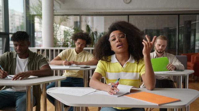 University high school academy college lecture class lesson difficulty task test exam African American woman girl female rise hand up ask question group of students classmates study education learning
