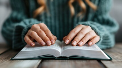 Soft hands clasp a book open on a rustic table, revealing pages filled with stories as gentle sunlight filters through a nearby window, creating a serene atmosphere