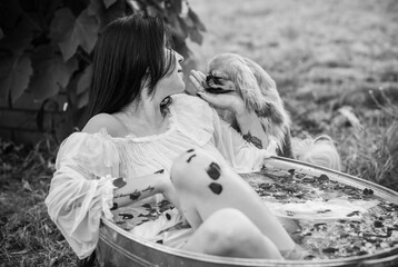 Woman in rustic bath with flowers. Concept of spa, some rite, wicca scene