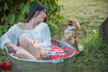 Woman in rustic bath with flowers. Concept of spa, some rite, wicca scene