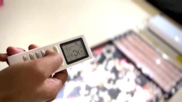 A Male Finger Operating The Room Air Conditioner Remote