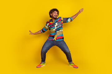 Full size photo of pretty young guy dance surfing wear trendy colorful outfit isolated on yellow color background